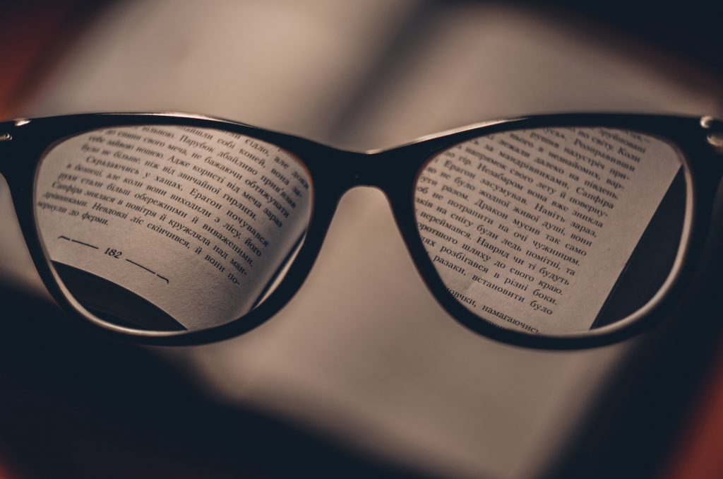 decorative image: glasses in front of a book