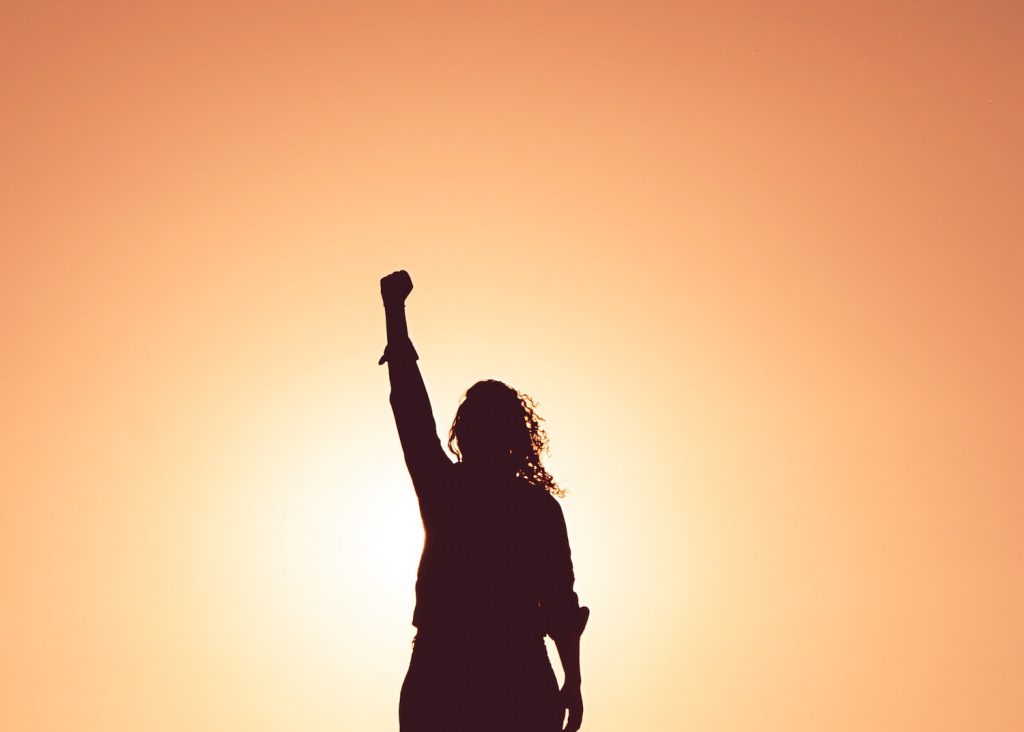 decorative image: woman with fist in the air
