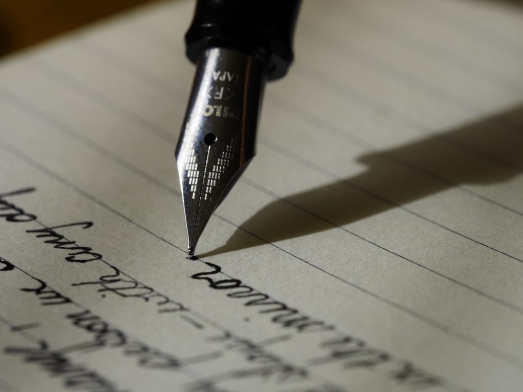 calligraphy on a page with a pen writing